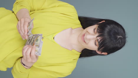 Vertical-video-of-Woman-counting-money-looking-at-camera.